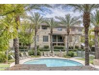Community pool surrounded by palm trees and lush landscaping offers a resort-like experience at 815 E Rose Ln # 105, Phoenix, AZ 85014