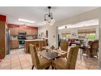 Open floorplan view of kitchen, dining area, and living room with lots of natural light at 8229 E Farmdale Dr, Mesa, AZ 85208