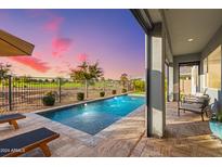 Inviting outdoor pool area with a fountain, lounge chairs, and a covered patio overlooking a manicured golf course at 11656 N San Clemente St, Surprise, AZ 85388
