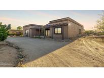 A house featuring a covered patio supported by a pergola and surrounded by desert landscaping at 20420 N 22Nd St, Phoenix, AZ 85024
