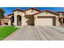 Charming home featuring a low-pitched red tile roof, neutral stucco, and a spacious driveway with a three car garage at 27089 N 172Nd Ln, Surprise, AZ 85387