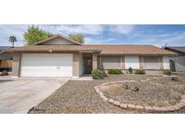 Charming single-story home featuring a well-maintained front yard with desert landscaping, brick accents, and a two-car garage at 402 W Mohawk Ln, Phoenix, AZ 85027