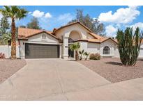 Inviting single-story home with a well-manicured front yard and a two car garage, surrounded by mature desert landscaping at 438 E Hackamore St, Mesa, AZ 85203