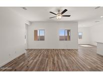 Bright, open living room features wood-look floors, ceiling fan, and double windows at 652 W Pintail Dr, Casa Grande, AZ 85122