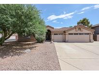 Single-story home showing the desert landscaping and spacious driveway leading to a two-car garage at 656 W Johnson Dr, Gilbert, AZ 85233
