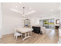 Elegant living room featuring light wood floors, a chandelier, and a cozy fireplace at 902 W Glendale Ave # 215, Phoenix, AZ 85021