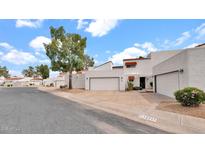 View of a charming white stucco home with a spacious two-car garage and well-maintained landscaping at 13811 N 42Nd Pl, Phoenix, AZ 85032