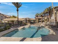Resort-style swimming pool with lounge seating, umbrellas, and a covered outdoor grilling area at 2025 E Campbell Ave # 114, Phoenix, AZ 85016