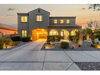 Inviting two-story home with a covered entryway, desert landscaping, and an attached two-car garage at dusk at 21266 S 213Th Pl, Queen Creek, AZ 85142