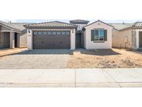 Charming single-story home with a well-manicured lawn and a two-car garage with brick paved driveway at 21296 N 270Th Dr, Buckeye, AZ 85396