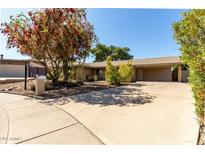 Charming single-story home featuring a covered carport, desert landscaping, and mature trees at 2433 E Acoma Dr, Phoenix, AZ 85032