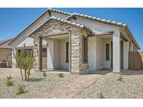 Charming home featuring a stone facade, covered porch, and low-maintenance landscaping, creating inviting curb appeal at 25188 N 174Th Ave, Surprise, AZ 85387
