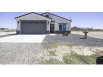 Charming single-story home featuring a gray two-car garage and desert landscaping at 3725 N Bandelier Dr, Eloy, AZ 85131