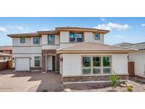 Stunning two-story home with a brick and stucco exterior, complemented by a well-manicured lawn and a driveway leading to a two car garage at 17827 W Medlock Dr, Litchfield Park, AZ 85340