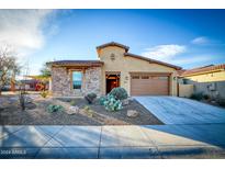 Charming single-Gathering home featuring a stone facade, desert landscaping, and a two-car garage at 18107 W Thunderhill Pl, Goodyear, AZ 85338