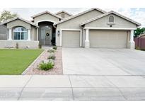 Charming home featuring a well-manicured lawn, a two-car garage, and a welcoming entrance at 1892 S Arroyo Ln, Gilbert, AZ 85295