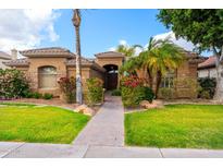 Charming single-story home with desert landscaping, manicured lawn, and a tiled roof in a sunny setting at 2452 W Enfield Way, Chandler, AZ 85286