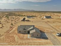 Expansive aerial view of desert homesite with custom home and mountain backdrop at 25721 W Running Deer Trl, Wittmann, AZ 85361