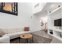 Bright living room with high ceilings, modern decor, and a cozy sofa at 4832 N Woodmere Fairway -- # C104, Scottsdale, AZ 85251