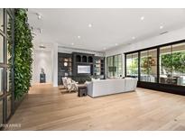 Bright, open living room with a living plant wall, large entertainment center, and sliding doors to the patio at 4901 E Lafayette Blvd, Phoenix, AZ 85018
