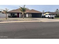 Charming single-story home features stone accents, well-maintained landscaping, and a convenient two-car garage at 5537 E Drummer Ave, Mesa, AZ 85206
