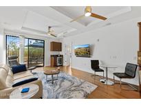 Bright living room features hardwood floors, ceiling fans, wet bar, and sliding glass door to balcony at 6803 E Main St # 1106, Scottsdale, AZ 85251