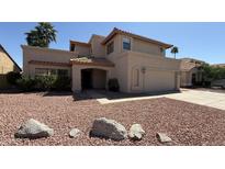Charming two-story home with a red rock yard and arched entrance at 7009 W Taro Ln, Glendale, AZ 85308