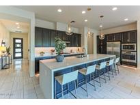 Modern kitchen with a large center island, pendant lighting, stainless steel appliances, and ample seating at 7330 E Vista Bonita Dr, Scottsdale, AZ 85255