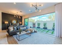 Bright living room featuring modern decor, stylish lighting, and a seamless indoor-outdoor flow to a landscaped patio at 7330 E Vista Bonita Dr, Scottsdale, AZ 85255