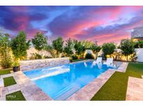 Inviting pool with waterfall feature, lush landscaping, and modern white lounge chairs at 851 E Deer Creek Rd, Phoenix, AZ 85048