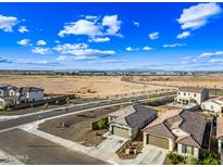 An aerial view shows the neighborhood and surrounding landscape with homes, streets, and expansive open land at 12472 W Kaler Dr, Glendale, AZ 85307