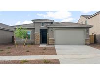 Charming single-story home featuring a tile roof, neutral stucco, stone accents, desert landscaping, and an attached two car garage at 17758 W Getty Dr, Goodyear, AZ 85338