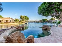 Inviting lagoon-style pool with rock features overlooks a scenic waterfront view and boat dock at 1833 W Mead Pl, Chandler, AZ 85248