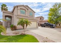 Charming two-story home featuring a well-maintained lawn, desert landscaping, and a convenient two-car garage at 2055 W Jasper Butte Dr, Queen Creek, AZ 85144