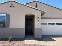 Charming single-story home featuring a neutral color palette, manicured gravel yard, and an attached two-car garage at 24493 W Grenadine Rd, Buckeye, AZ 85326
