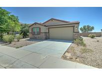 Charming single-story home featuring a two-car garage and low maintenance desert landscaping with stone accents at 25755 W Hazel Dr, Buckeye, AZ 85326
