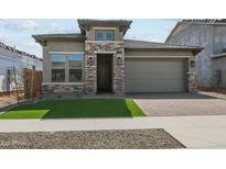 Charming single-story home featuring stone accents, a two-car garage and well-manicured front lawn at 26079 S 228Th St, Queen Creek, AZ 85142