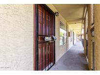 Exterior door with security gate and unit number, offering secure and private entry to the condominium at 461 W Holmes Ave # 224, Mesa, AZ 85210