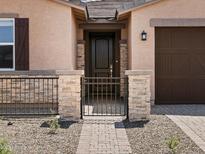Charming home entrance featuring a secure front gate and covered porch at 4819 N 177Th Ln, Goodyear, AZ 85395