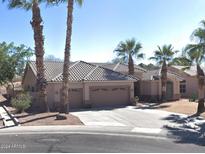 Beautiful single-story home featuring well-manicured landscaping, a three-car garage, and desert accents like palm trees at 665 W Beechnut Dr, Chandler, AZ 85248