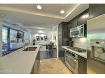 Modern kitchen featuring stainless steel appliances and a large countertop with a sink overlooking the living area at 7151 E Rancho Vista Dr # 3010, Scottsdale, AZ 85251