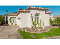 Inviting single-story home featuring desert landscaping, a tile roof, and an attached garage at 7538 E Tuckey Ln, Scottsdale, AZ 85250