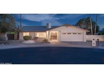 Charming single-story home featuring a brick exterior, two-car garage, and beautifully maintained landscaping at 932 S Pico Cir, Mesa, AZ 85206