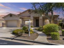 Charming single-story home with desert landscaping, covered entryway, and attached two-car garage at 9733 W Hedge Hog Pl, Peoria, AZ 85383