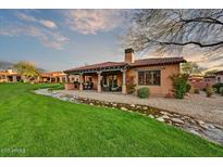 Charming backyard with a covered patio, beautiful landscaping, and a serene water feature at 7680 E Golden Eagle Cir, Gold Canyon, AZ 85118