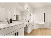 Elegant bathroom with dual sinks, quartz countertops, and separate tub at 1112 E Winged Foot Dr, Chandler, AZ 85249