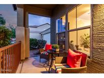 Cozy covered patio with wicker furniture, bright red cushions, and a charming outdoor seating area at 18217 E El Viejo Desierto --, Gold Canyon, AZ 85118