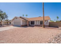 Charming single-story home with a well-maintained front yard with neutral colors and desert landscaping at 4906 E Evergreen St, Mesa, AZ 85205
