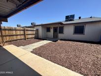 A nice backyard with a wood fence, wood chips, and a patio walkway at 5120 W Willow Ave, Glendale, AZ 85304
