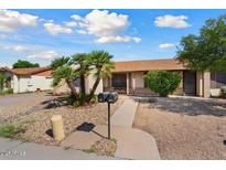 Charming single-story home featuring desert landscaping and mature palm trees on a sunny day at 5120 W Willow Ave, Glendale, AZ 85304